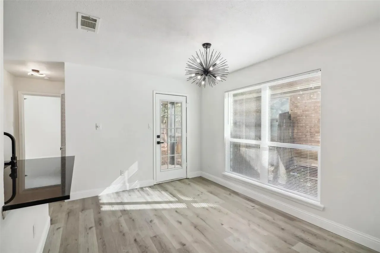Dining area featuring a modern sputnik chandelier, light wood-finish flooring, and a glass-paned door