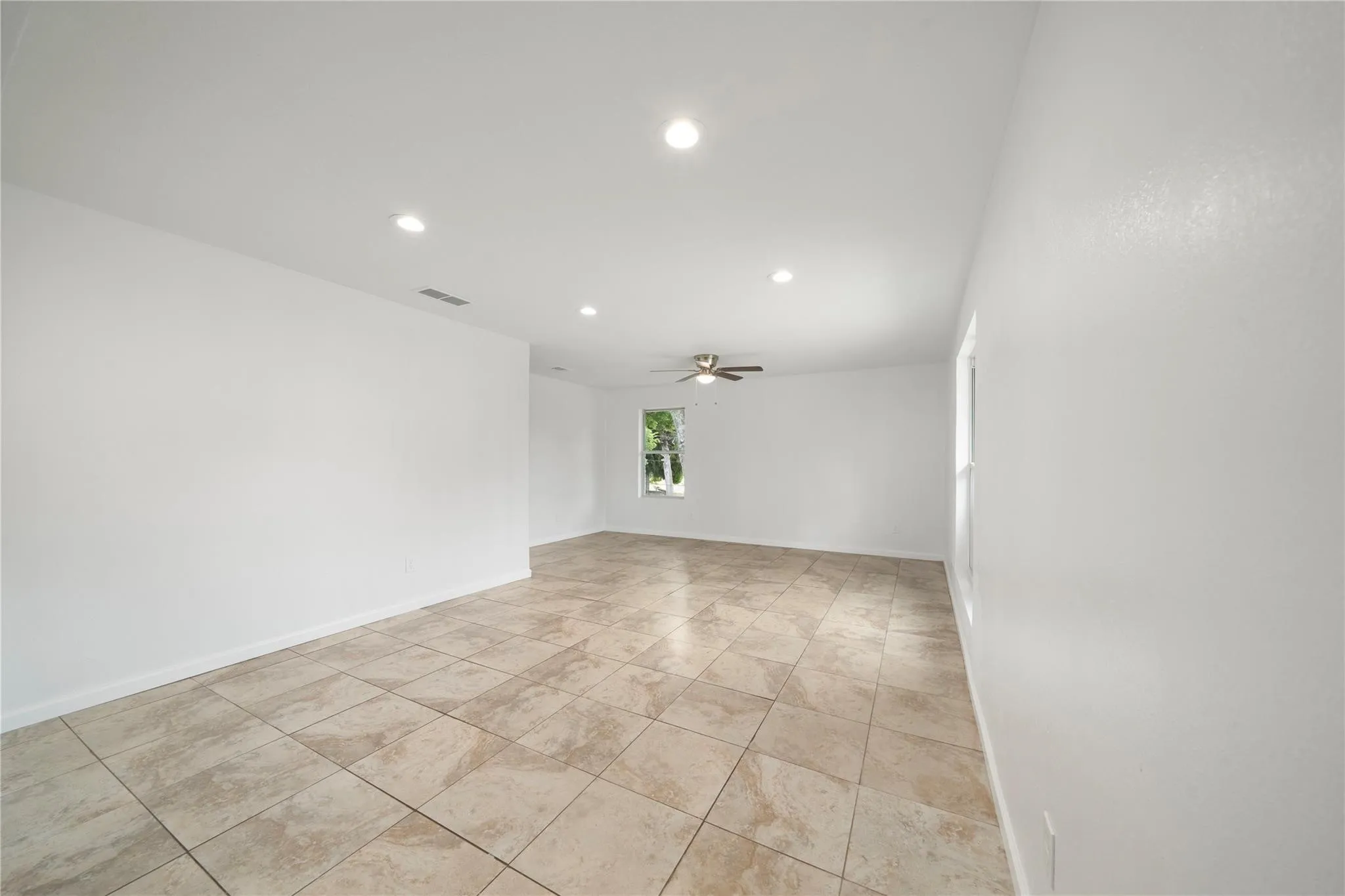 Spacious interior with neutral wall finishes and large format floor tiling