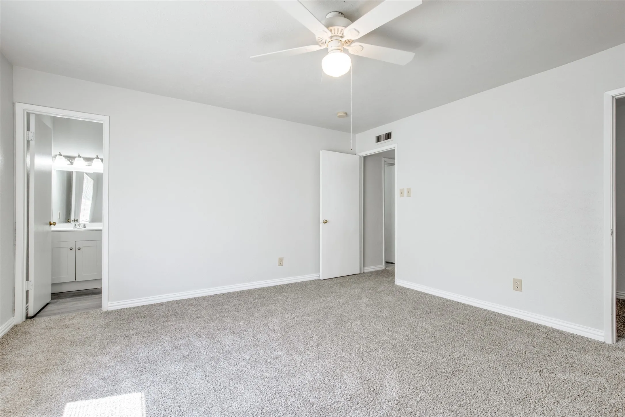 Spacious room with light gray carpet and white walls