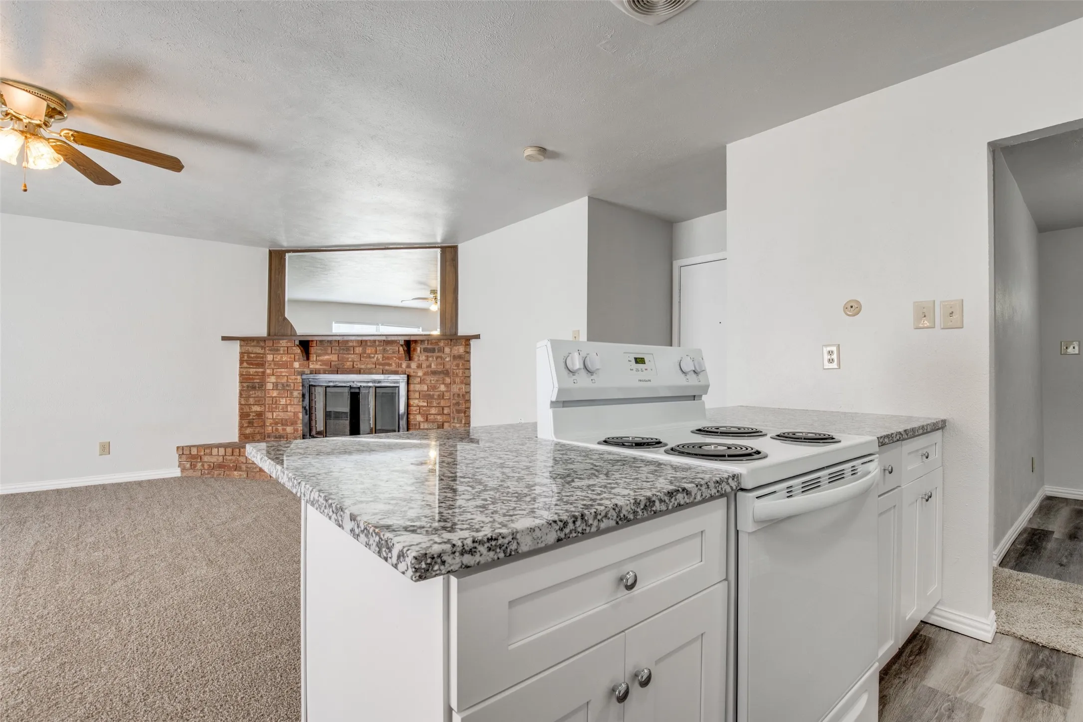 Kitchen island featuring a granite-style countertop and white cabinetry with brushed nickel hardware