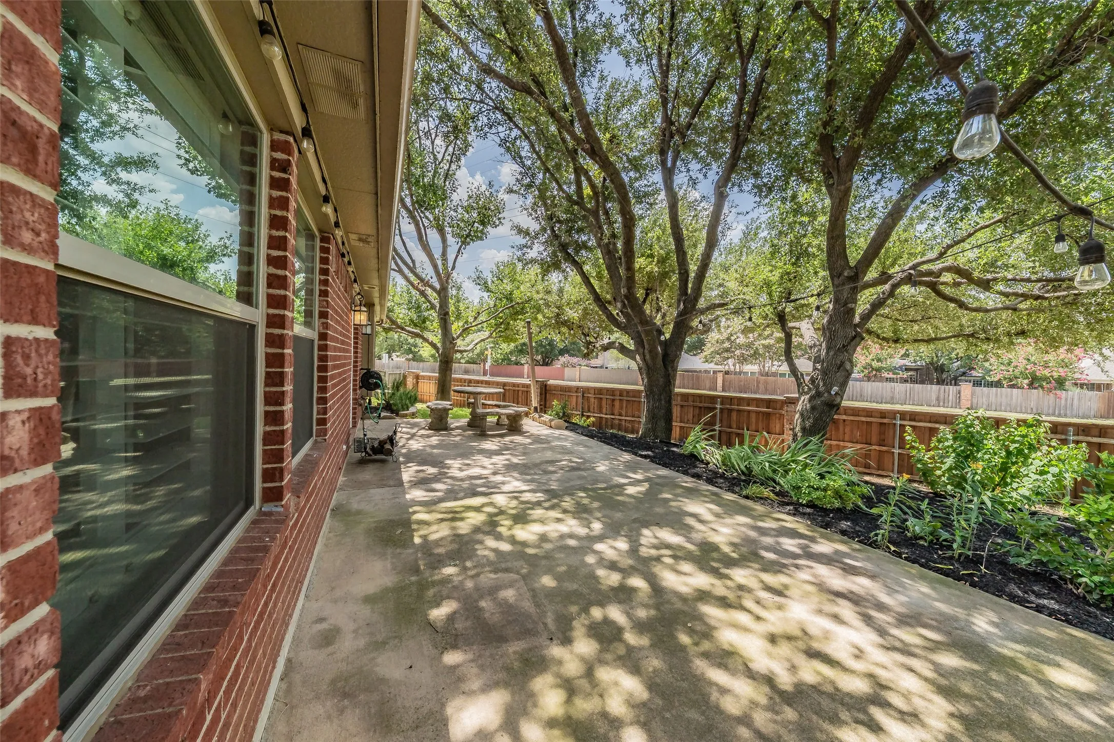 Backyard patio & large trees offering plenty of shade.
