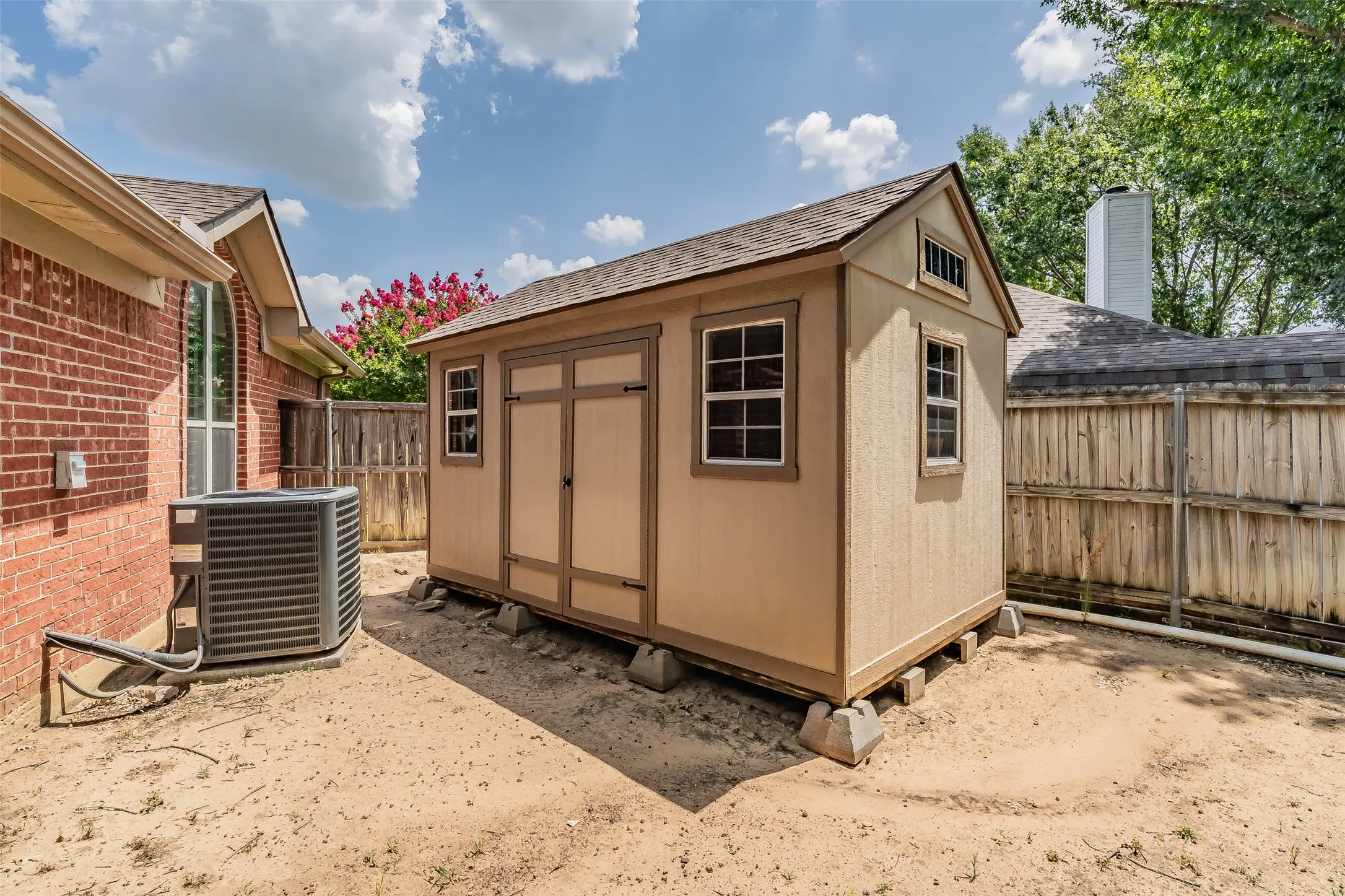 Freestanding storage shed featuring dual entry doors and multiple windows