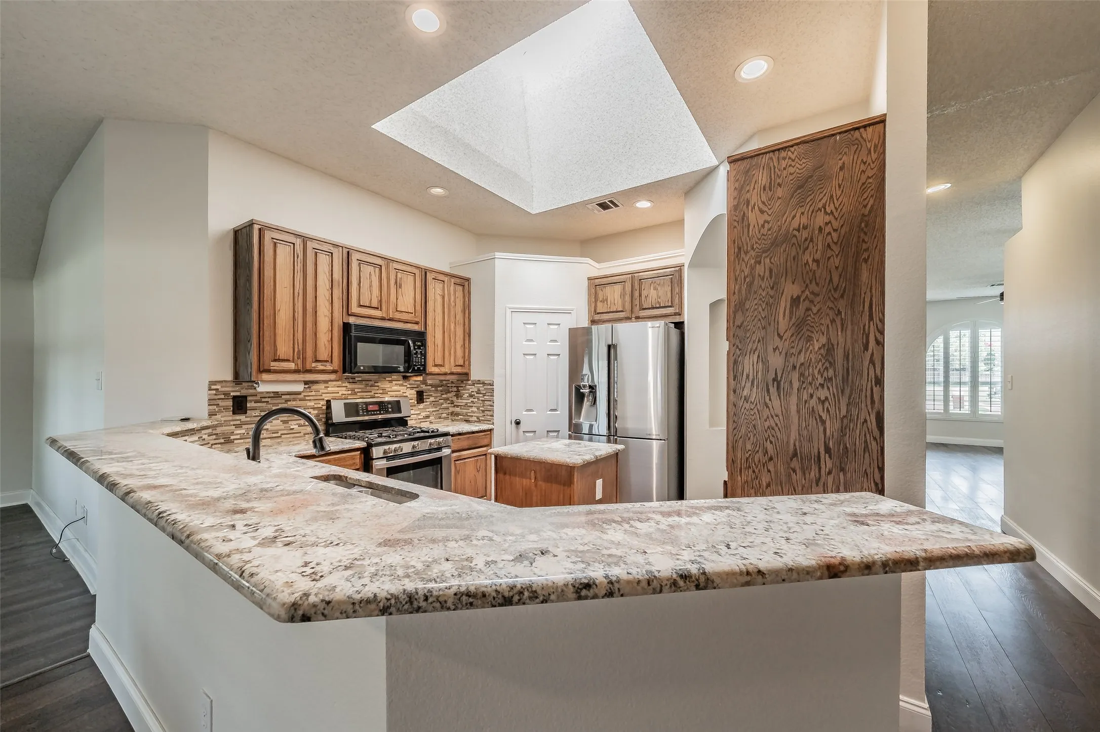 Kitchen featuring a large breakfast bar for added seating and is open the breakfast area and family room.  Large skylight offers plenty of natural light.