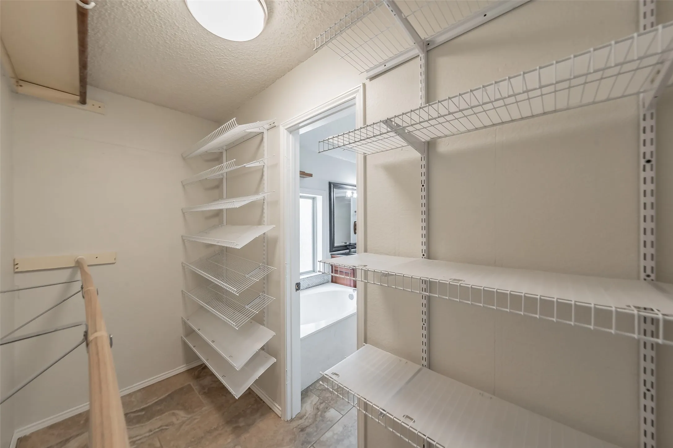 Primary bathrooms with large walk-in closet with extensive wire shelving and a multi-tiered shoe rack for the shoe lover in the family.