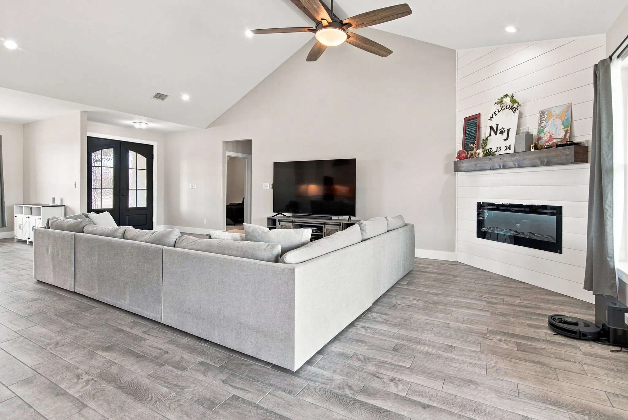 Spacious living area featuring vaulted ceilings with a ceiling fan, wood-finish flooring, and recessed lighting