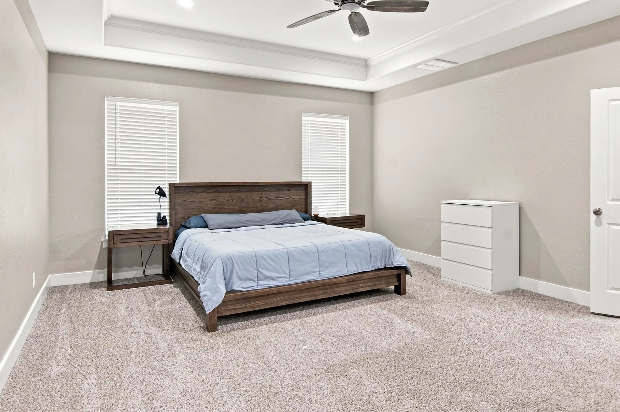 Spacious room featuring tray ceiling, recessed lighting, neutral-toned walls, and carpet flooring
