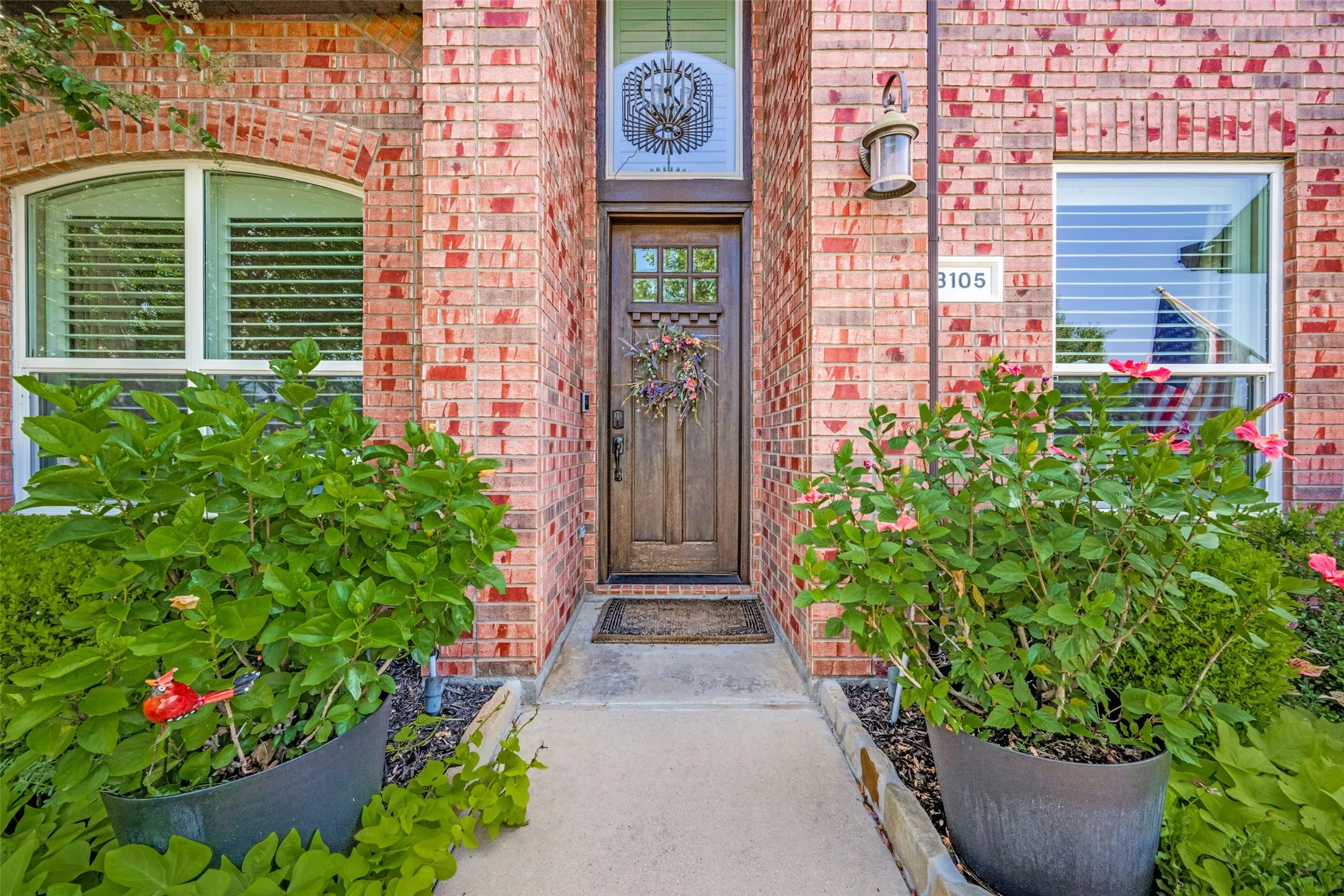 Brick exterior featuring a wood-paneled entry door with transom window
