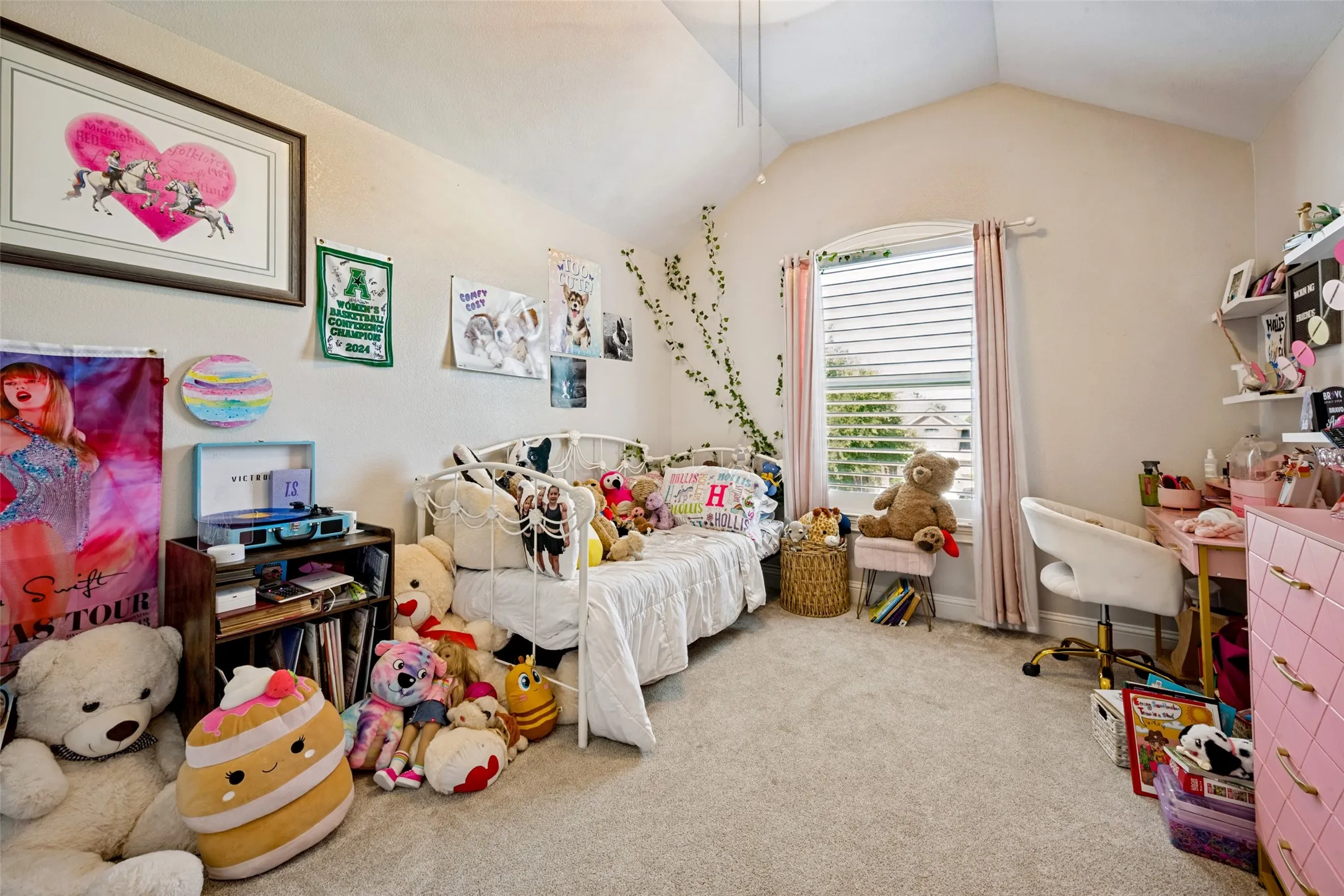 Spacious room featuring vaulted ceilings and neutral-toned carpeting