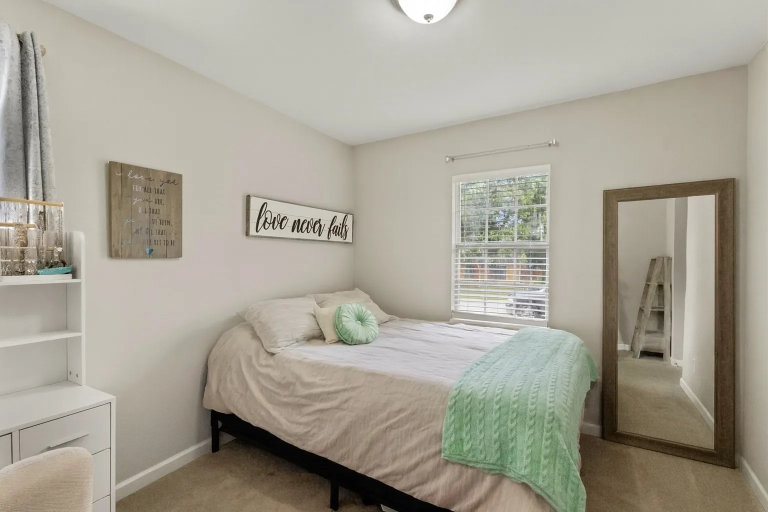 Bedroom featuring neutral wall color, carpet flooring, a single window with blinds, and a flush mount ceiling light fixture