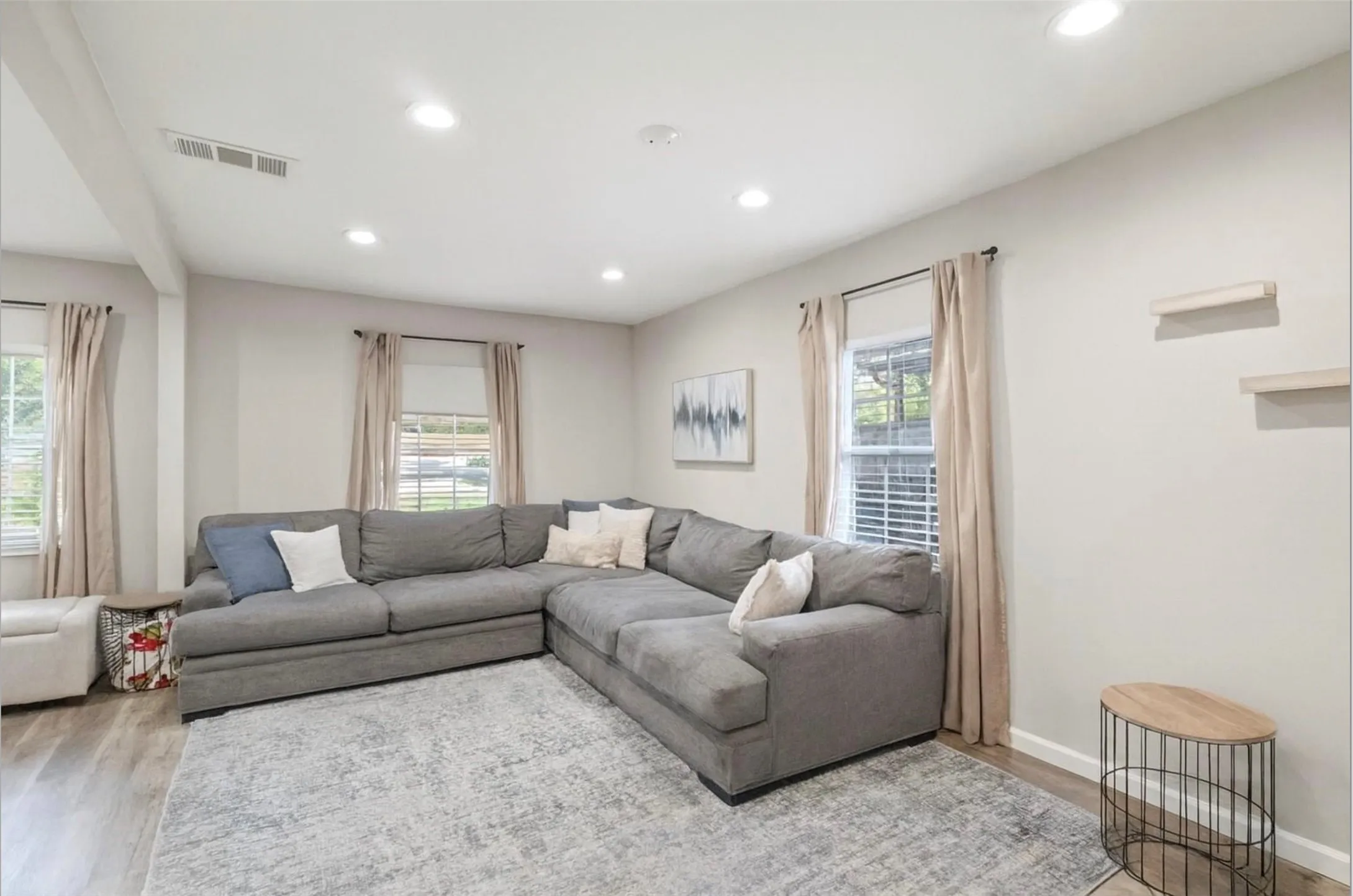 Recessed lighting, wood-finish flooring, multiple windows with blinds, and floating wall shelves