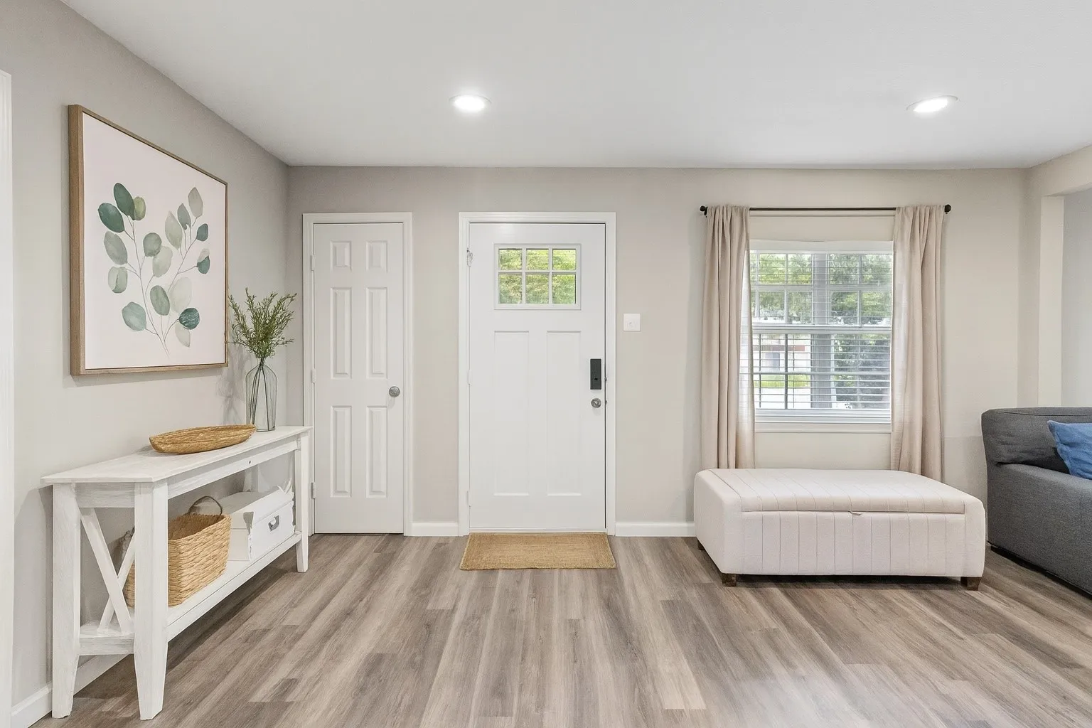 Entryway featuring wood-finish flooring, a white paneled entry door with windowpanes, and recessed lighting