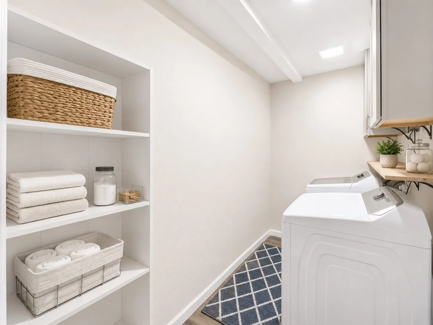 Dedicated laundry space featuring white built-in shelving, wood-finish flooring, and overhead lighting