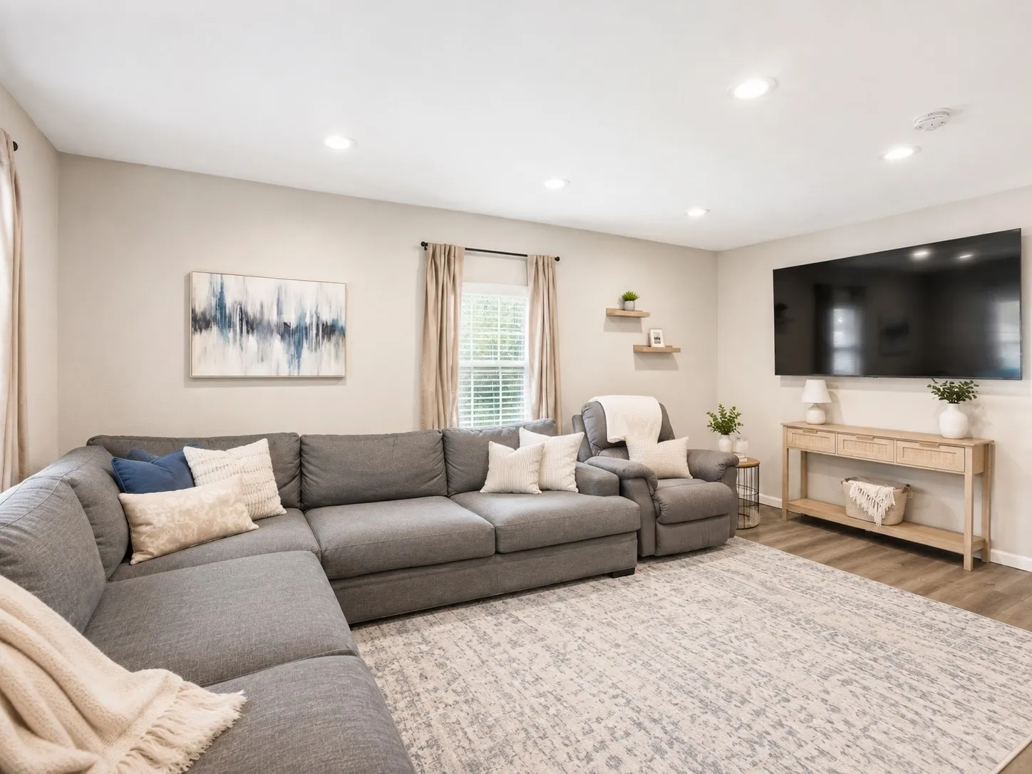 Recessed ceiling lighting, light-toned wall finishes, window with blinds, wood-finish flooring, and floating wall shelves