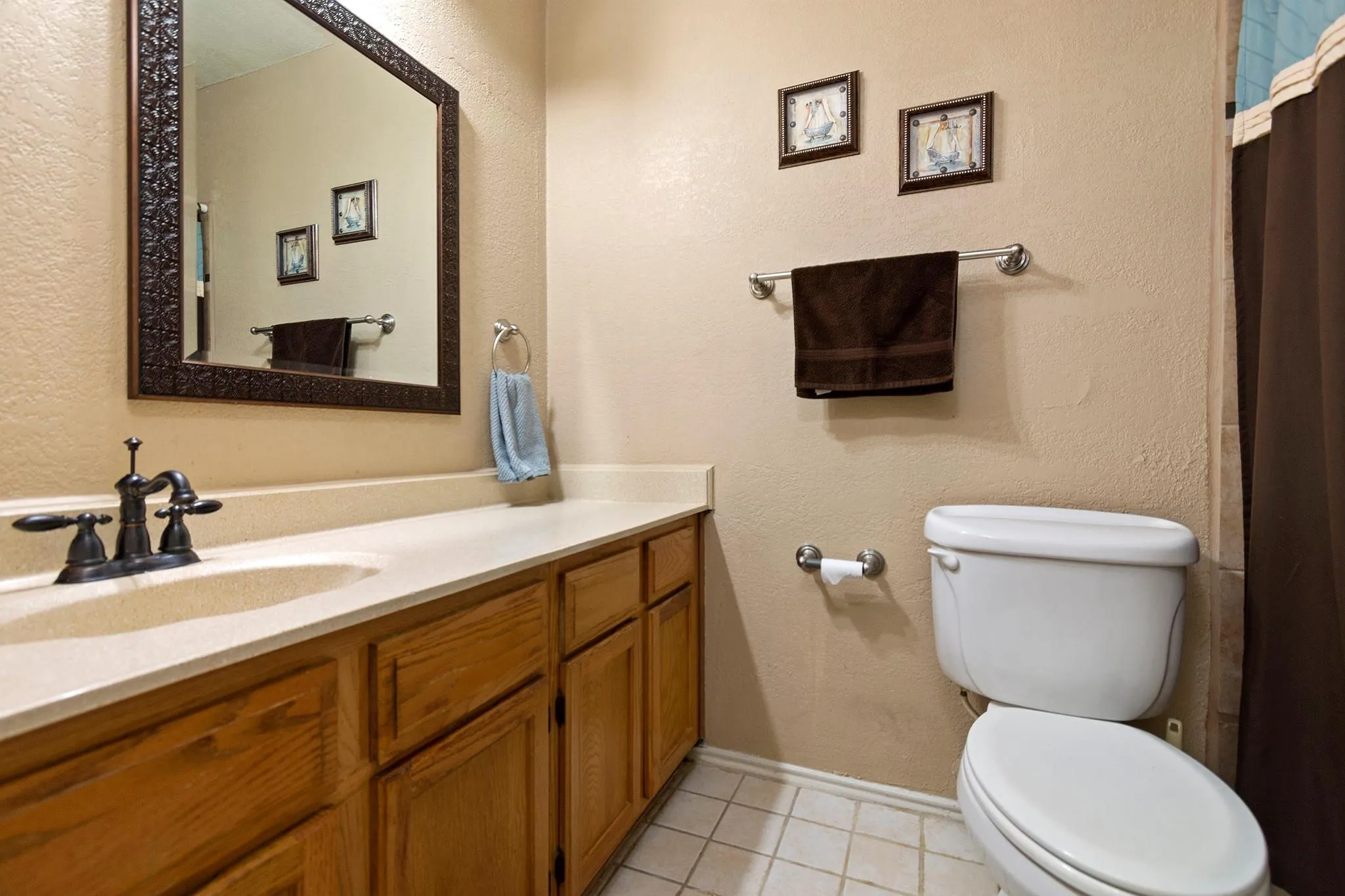 Bathroom featuring a vanity with integrated sink, light-toned countertop, and wood-finish cabinetry