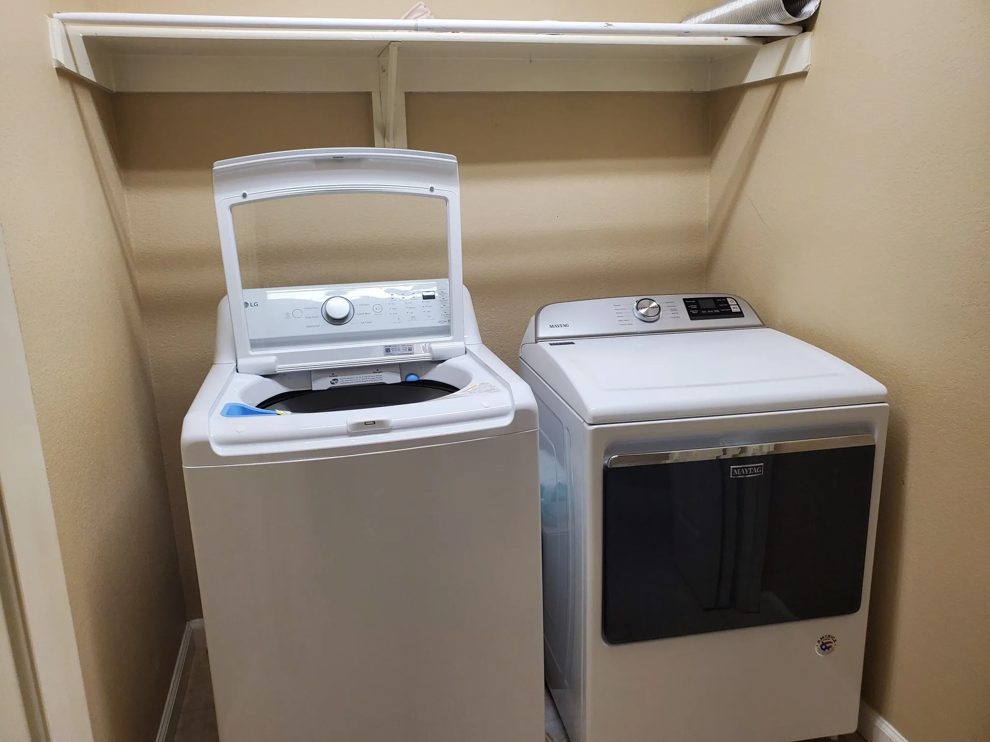 Dedicated laundry area featuring a top-loading washer and a front-loading dryer, both in white