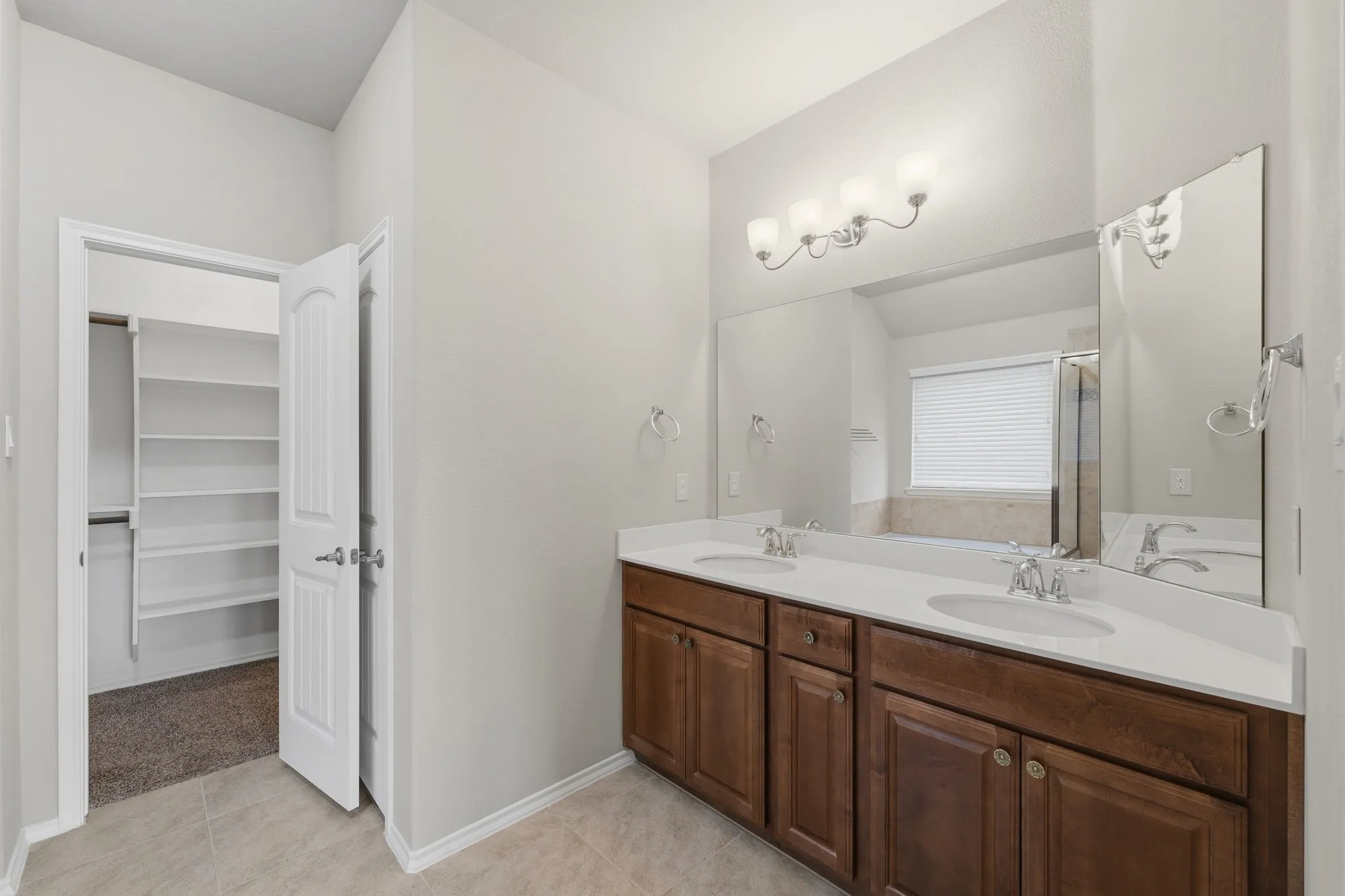 Dual vanity with white countertops, undermount sinks, and chrome fixtures