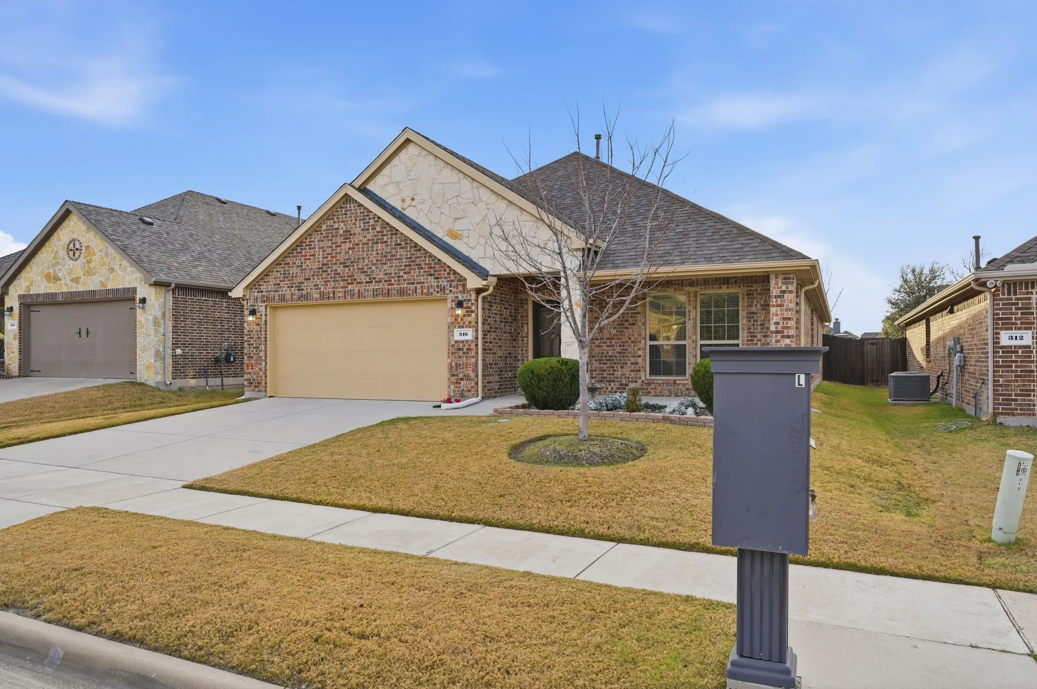 Brick and stone facade residence with an attached garage