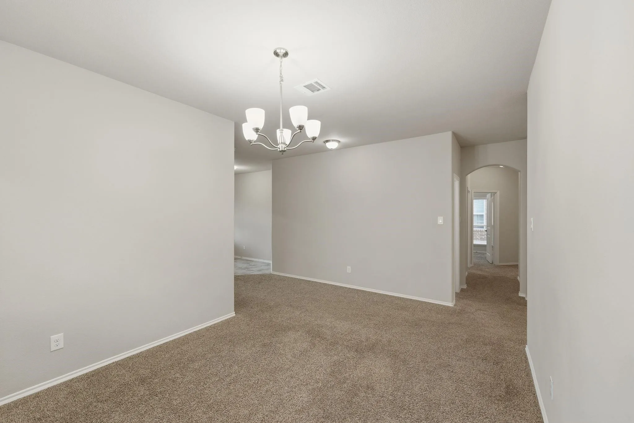Open concept living space featuring neutral carpet flooring, light gray wall paint, and white trim