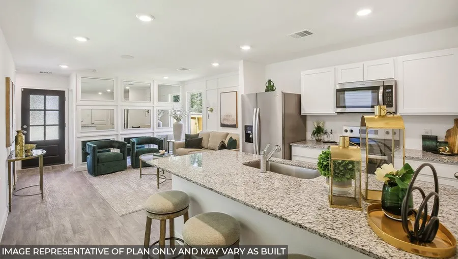 Open-concept living area featuring wood-finish flooring, recessed lighting, and a kitchen with a large granite countertop island, stainless steel appliances, and white cabinetry