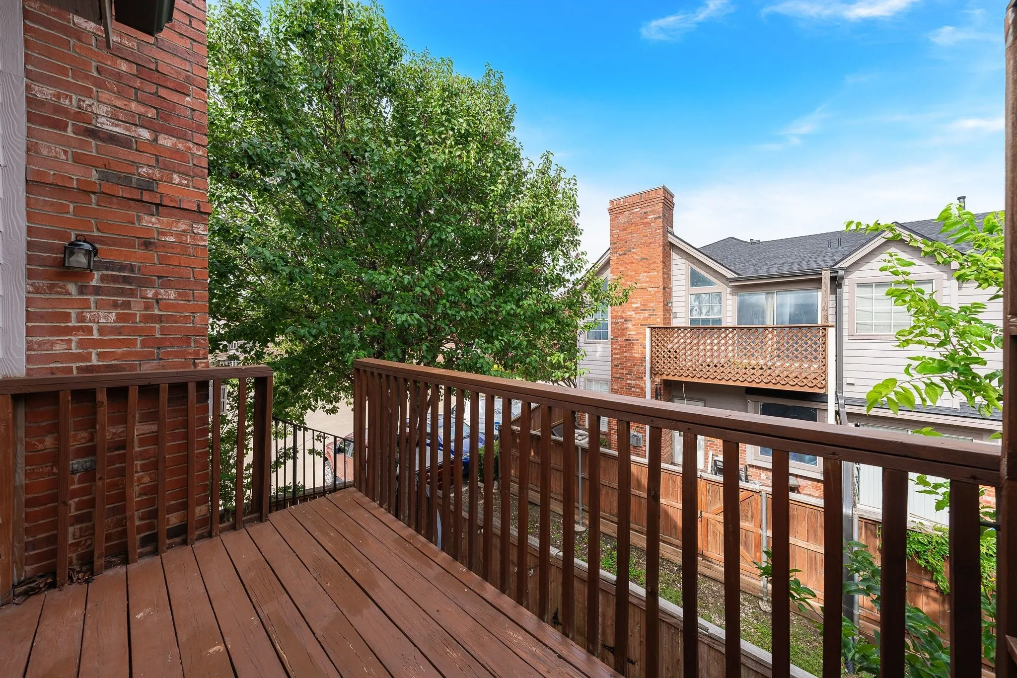 Private exterior balcony with wood-finish decking and railing