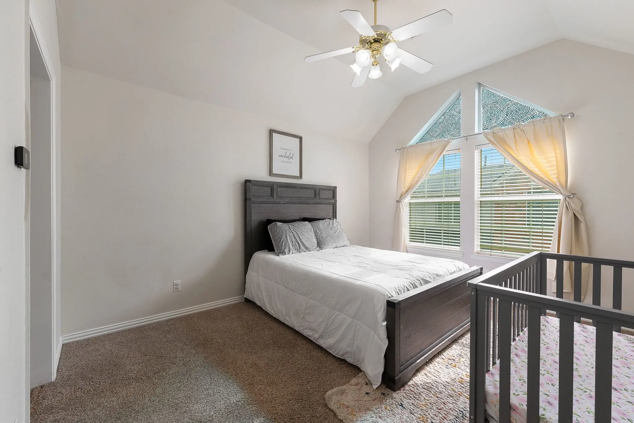 Vaulted ceiling room featuring carpet flooring and white baseboards