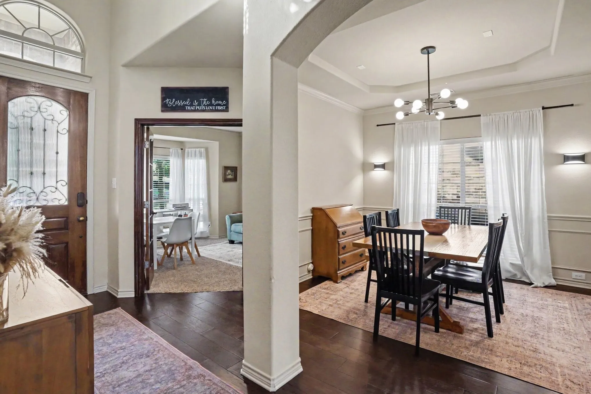 Entry foyer with dark wood-finish flooring and an ornate glass-paneled front door