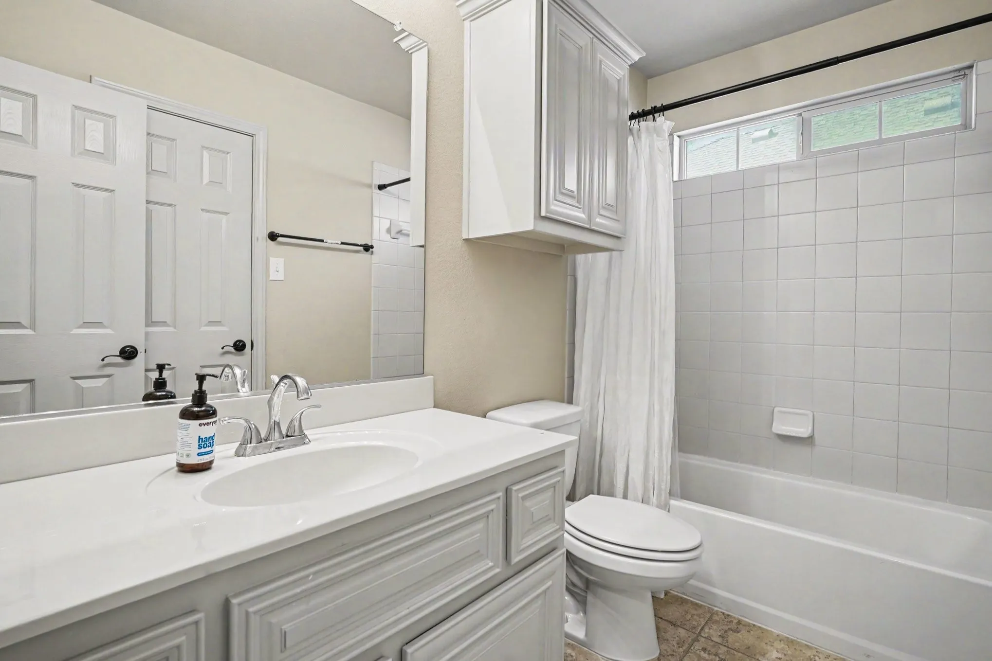 Bathroom vanity with an integrated sink, polished chrome faucet, and decorative mirror