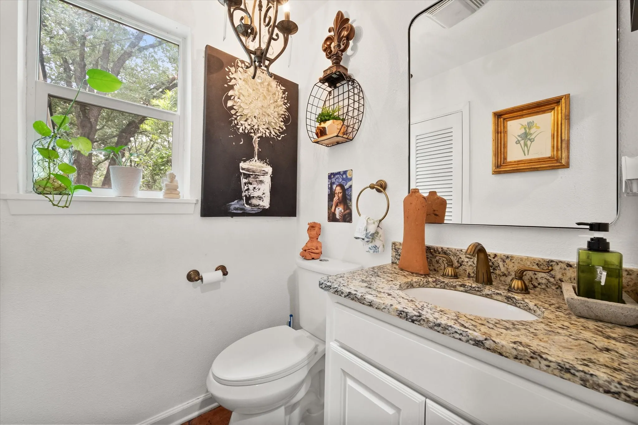 Vanity with a granite countertop, dual-handle bronze faucet, and an oval undermount sink