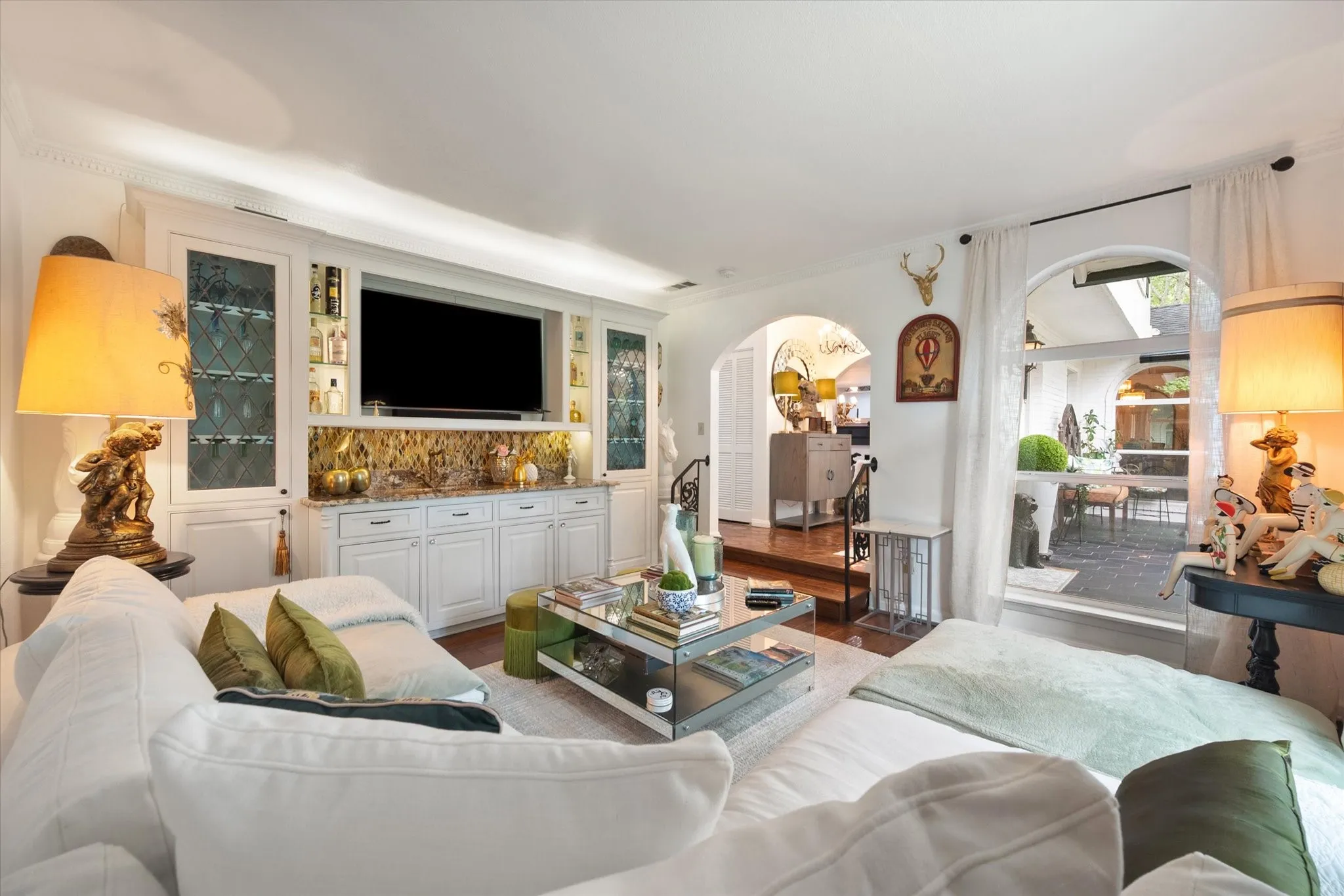 Integrated custom cabinetry with a media niche, backlit shelving, and lower storage