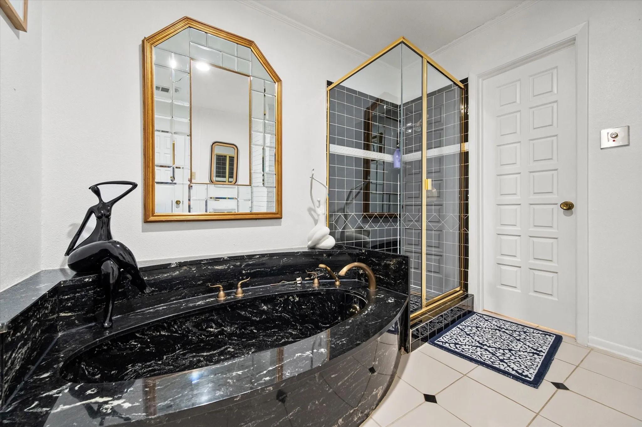 Black granite soaking tub with brass fixtures