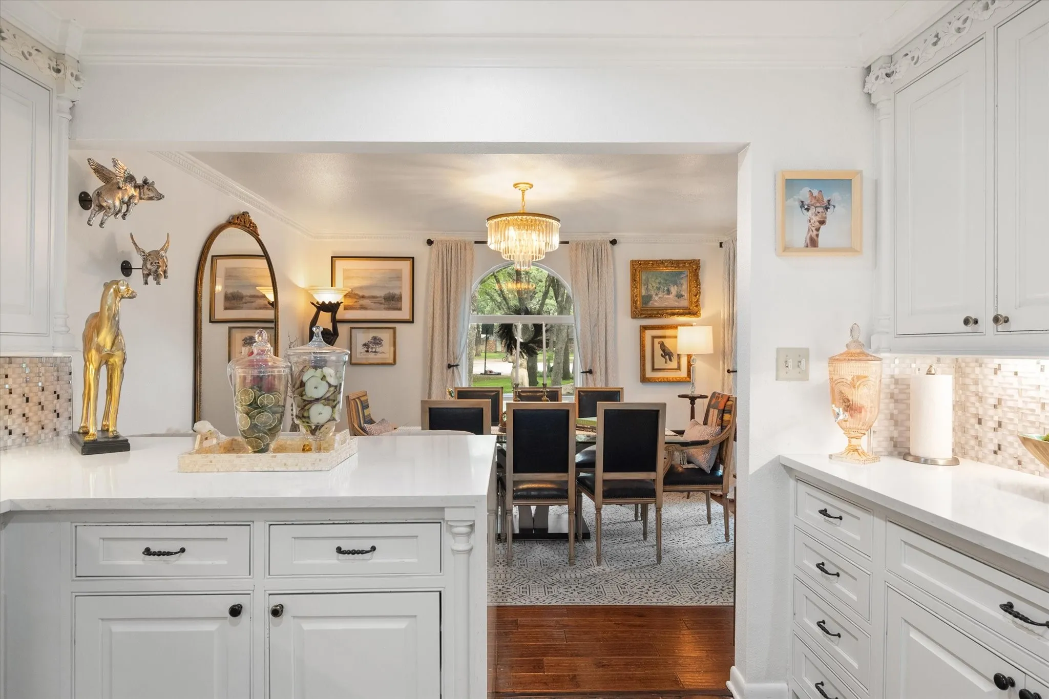 Kitchen featuring white cabinetry with dark hardware, a light-toned countertop, and a mosaic tile backsplash