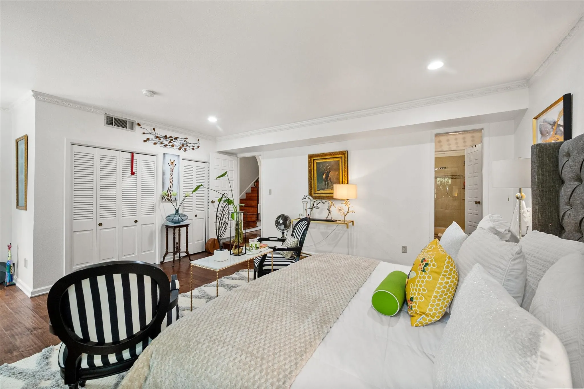 Spacious room featuring wood-finish flooring, recessed lighting, crown molding, and louvered bi-fold closet doors
