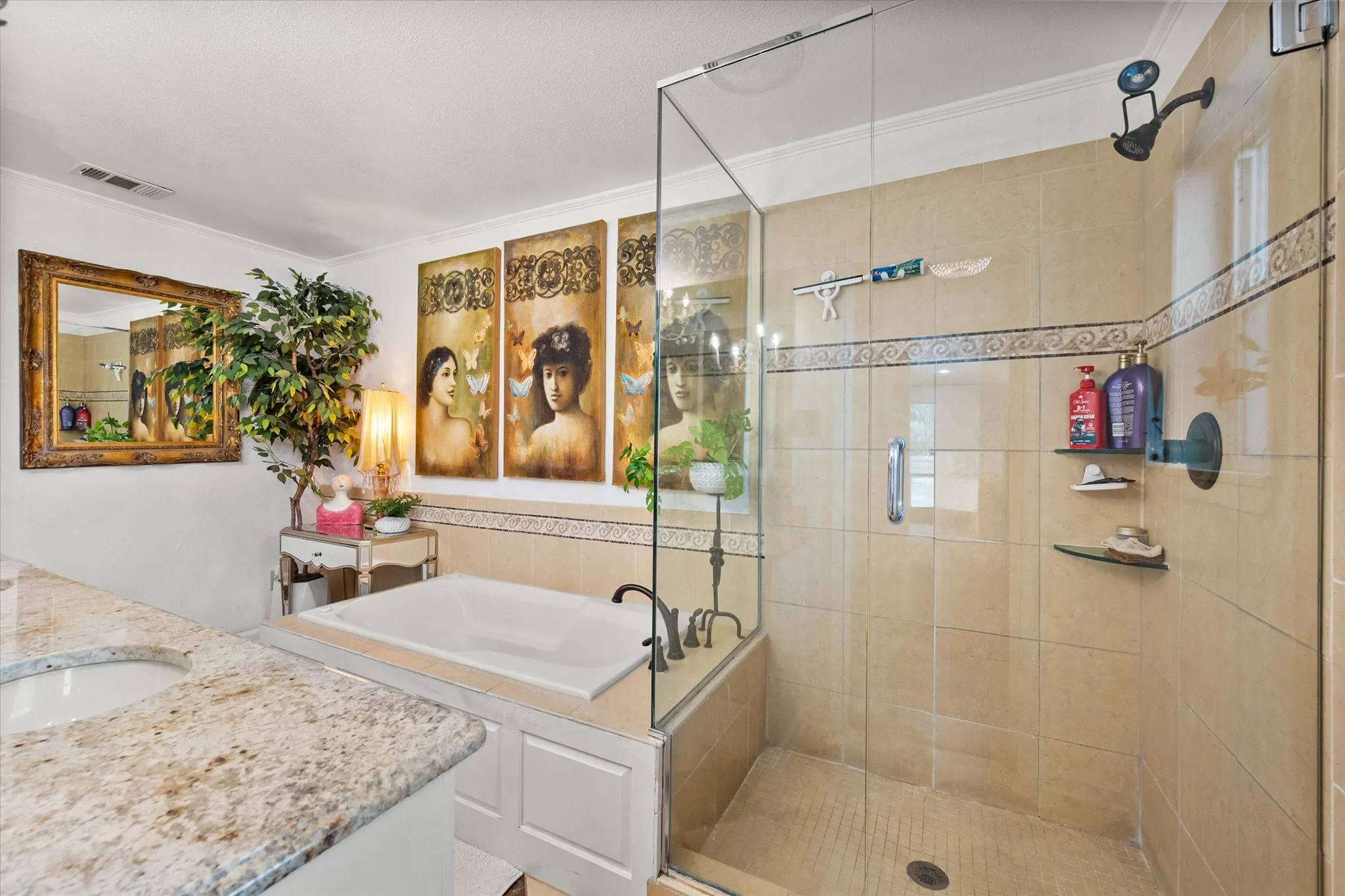 Bathroom featuring a built-in soaking tub, a frameless glass shower enclosure, and a double vanity with stone countertops