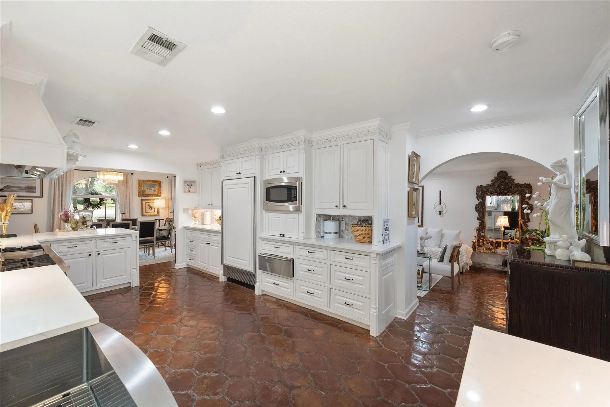 Spacious kitchen featuring white cabinetry, stone countertops, stainless steel appliances, recessed lighting, and hexagonal tile flooring