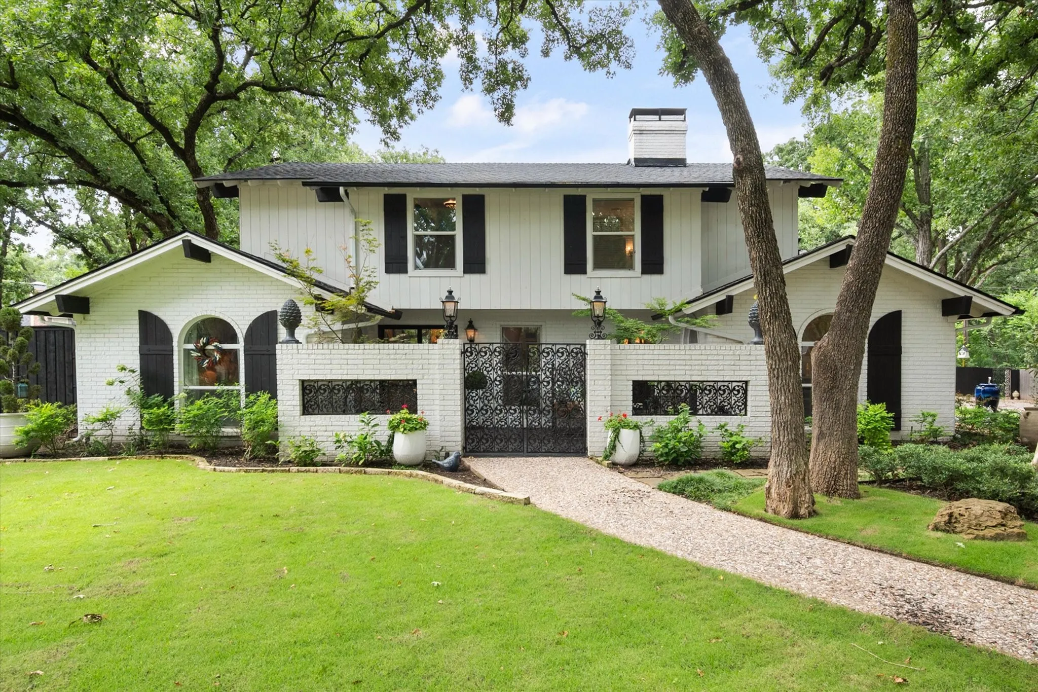 White brick exterior with black shutters and a black shingle roof
