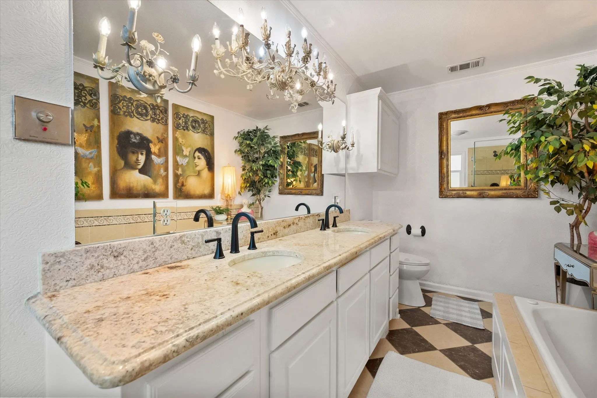 Bathroom featuring a dual vanity with a light-toned countertop, two integrated sinks, and matte black fixtures