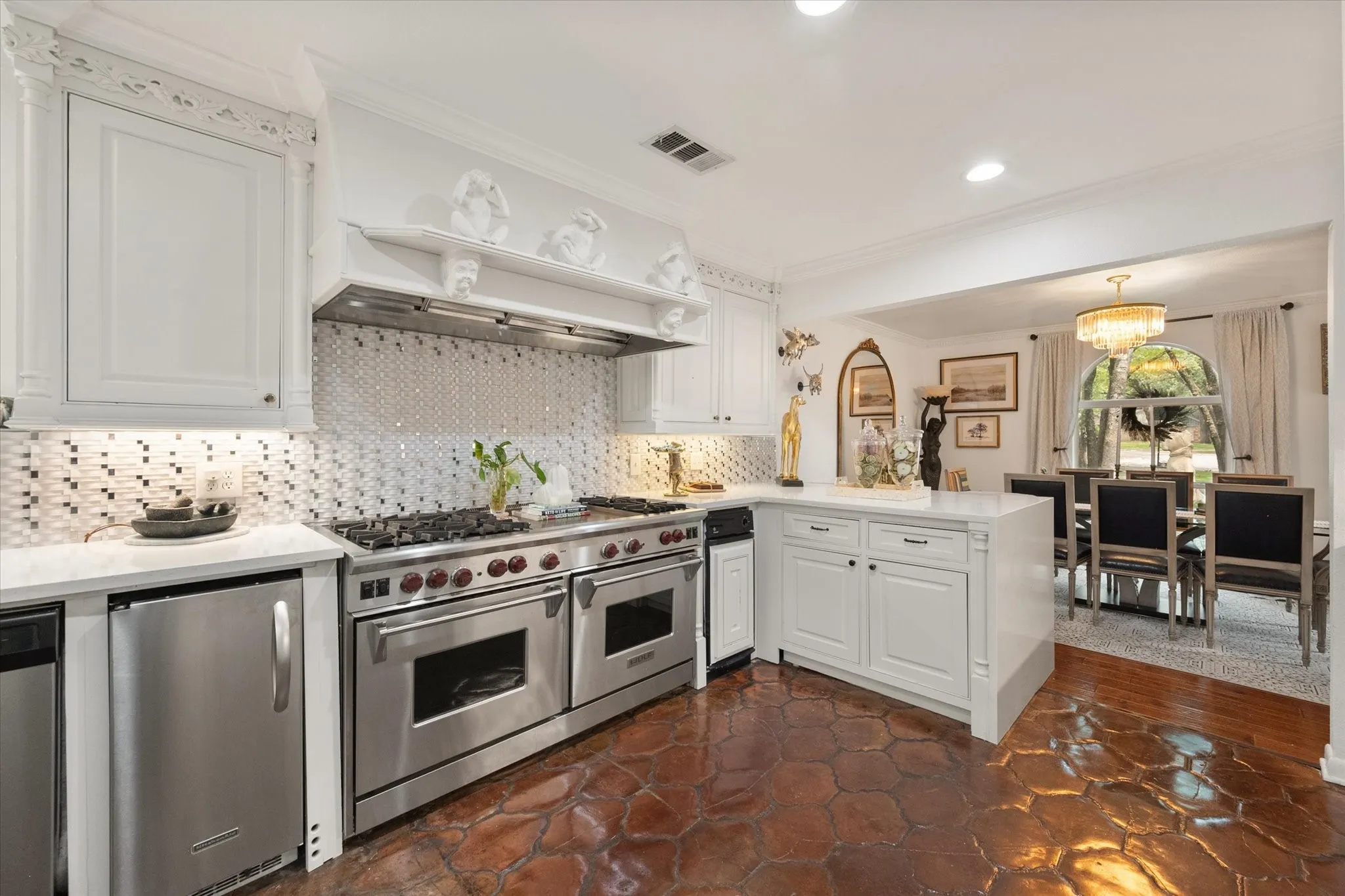 Gourmet kitchen featuring a professional-grade stainless steel range with double ovens, white shaker cabinetry, mosaic tile backsplash, and quartz countertops