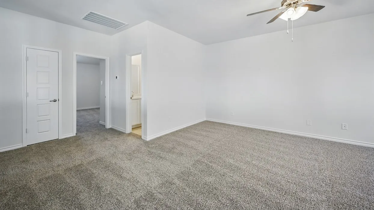 Spacious room featuring neutral carpet flooring, white painted walls, and a ceiling fan with integrated lighting