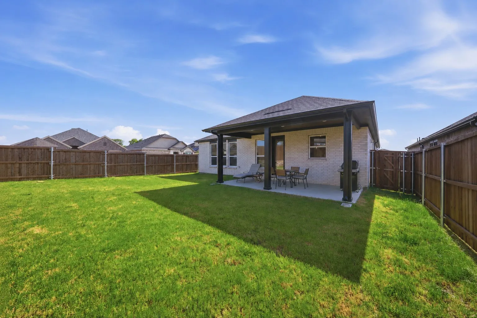 Expansive backyard featuring a manicured lawn and a full privacy fence