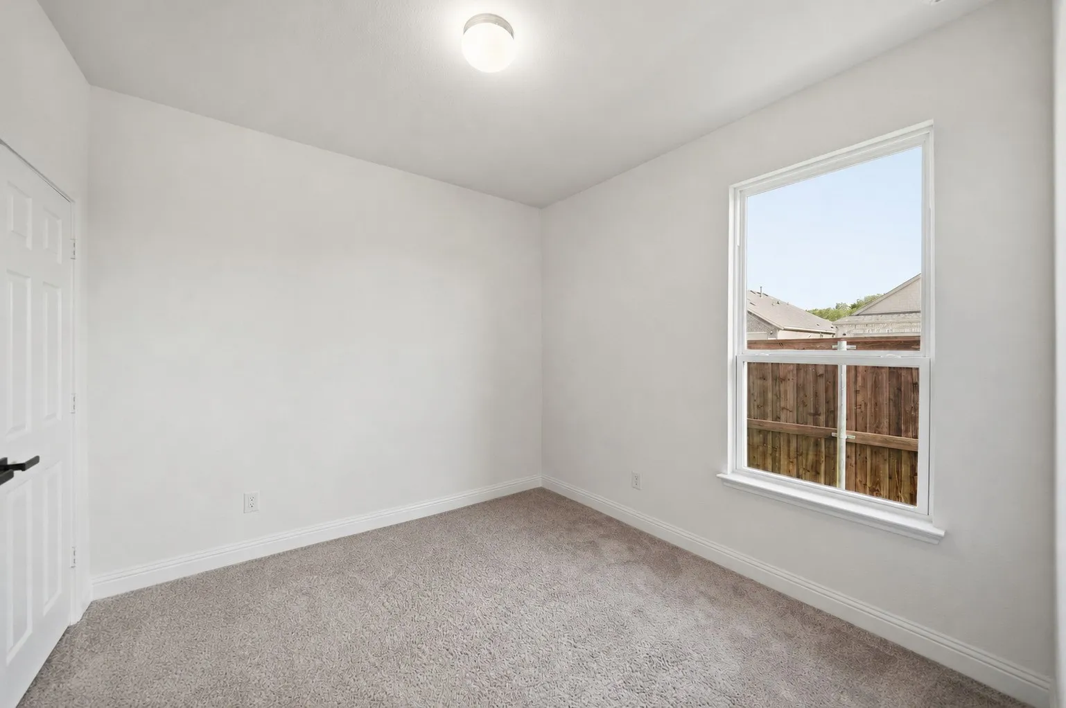 Bedroom 3 featuring a window, neutral wall paint, and light-colored carpet flooring