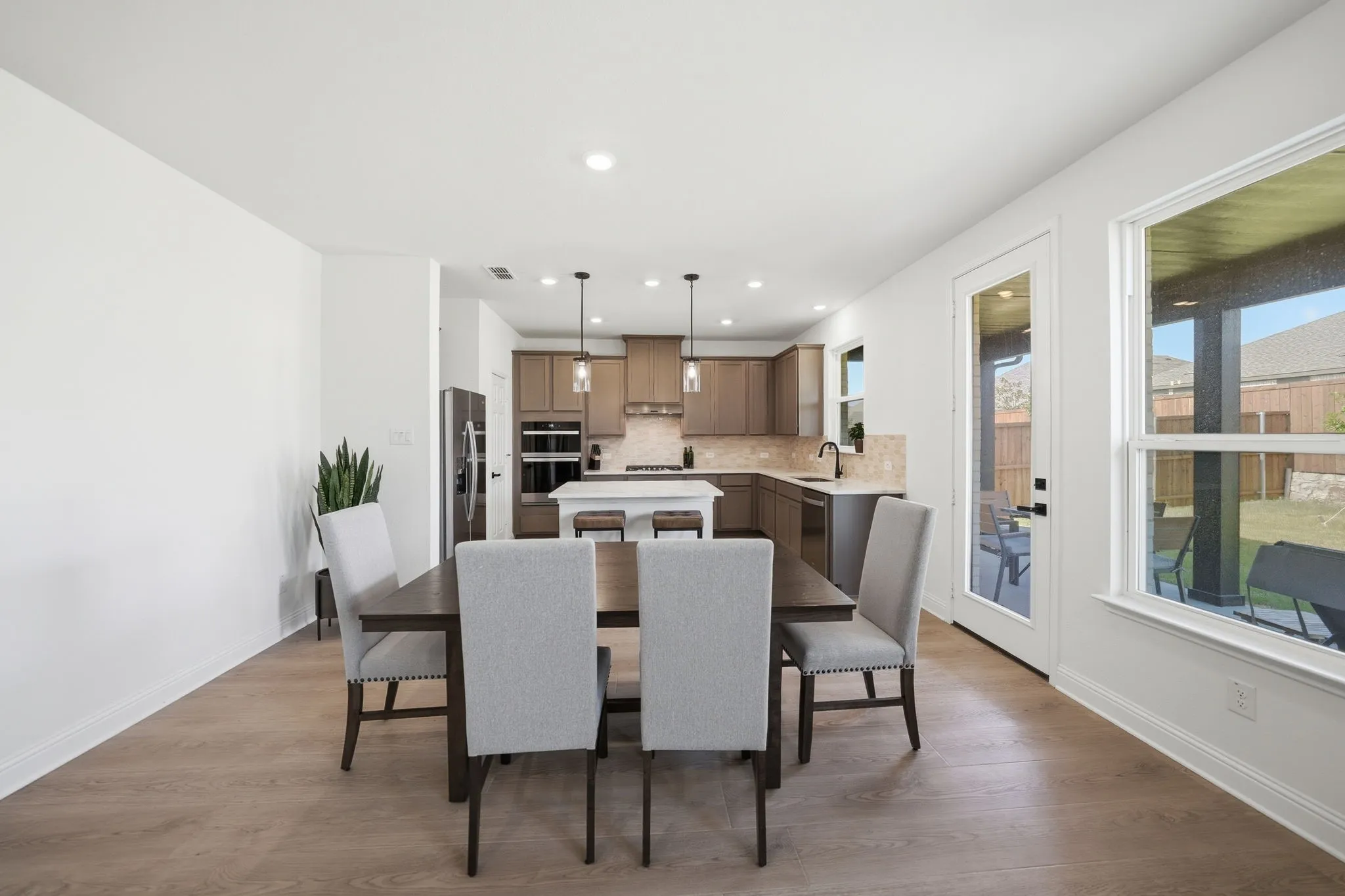 Open-concept dining area featuring wood-finish flooring, recessed lighting, and a white trim package