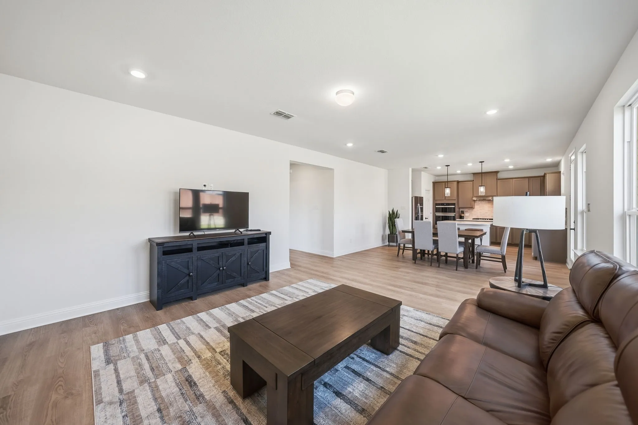 Open-concept living area featuring wood-finish flooring and recessed lighting