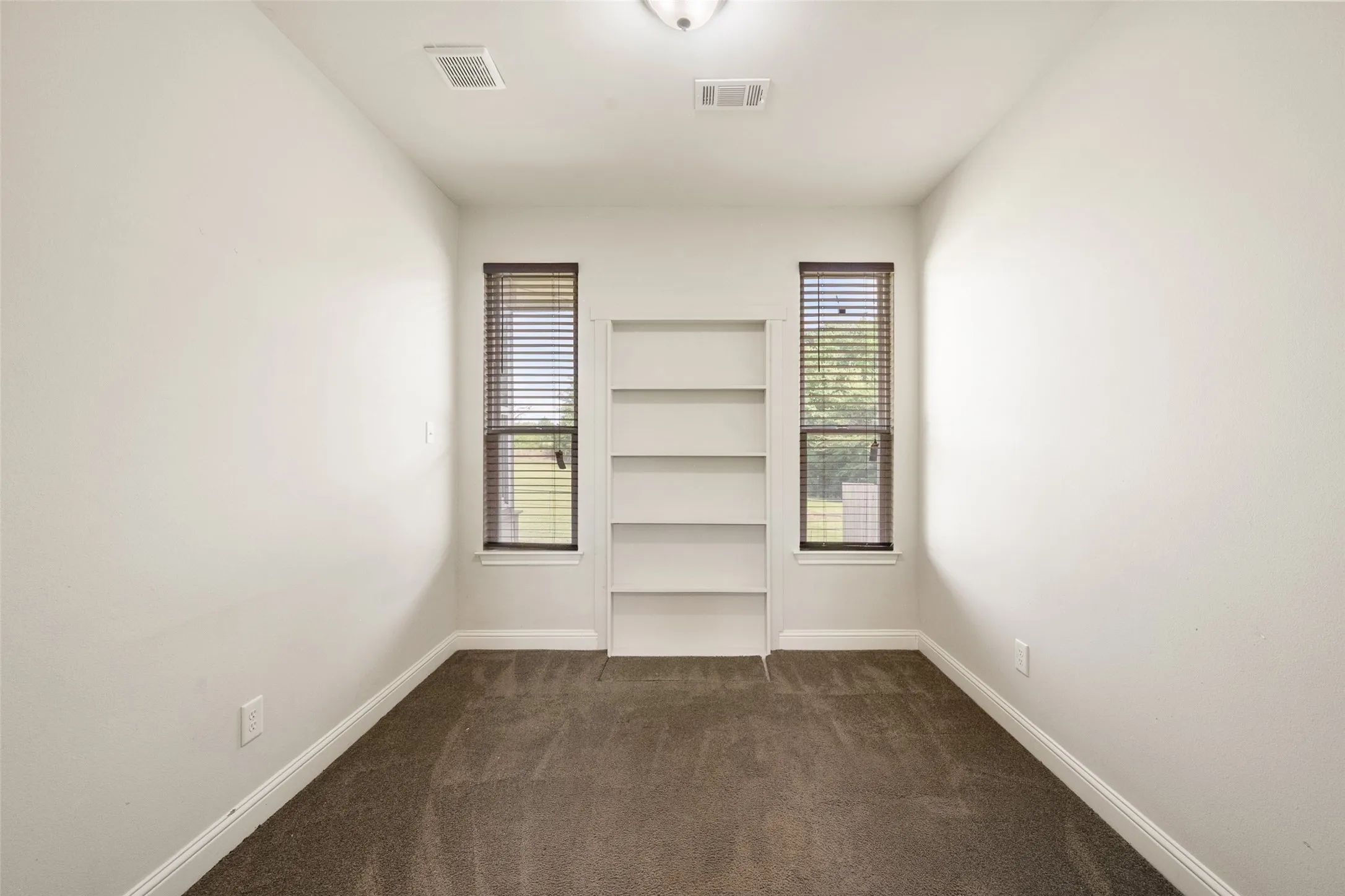 Flexible bonus room with built-in shelving, backyard-facing windows and excellent potential for hobbies or storage.
