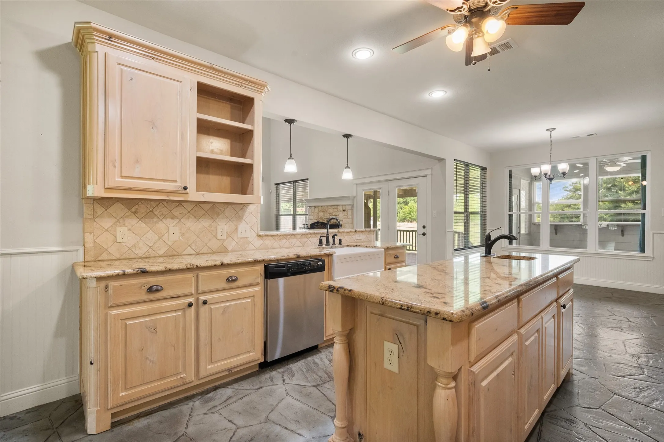 Large kitchen island with granite counters, abundant storage, dishwasher and open access to the breakfast area.