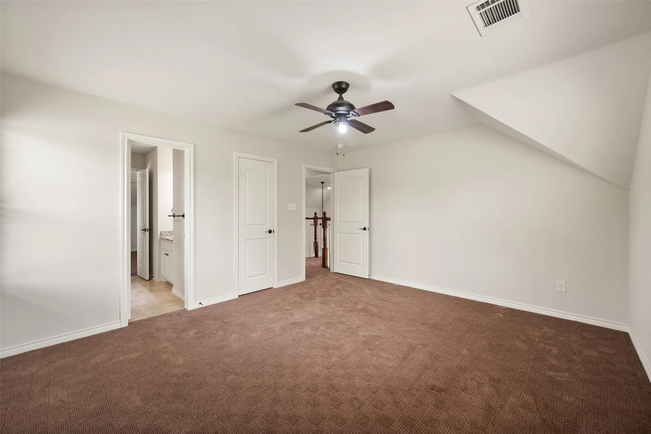 Large upstairs bedroom with ensuite bathroom access, ceiling fan and walk-in closet.