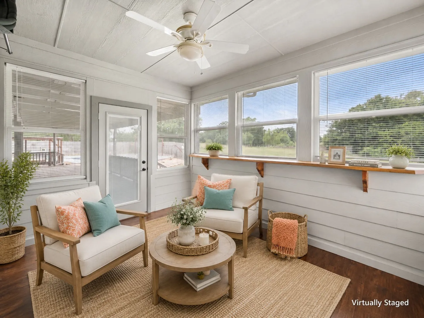 Virtually staged sunroom retreat with cheerful seating, natural textures and teal and coral accent colors.