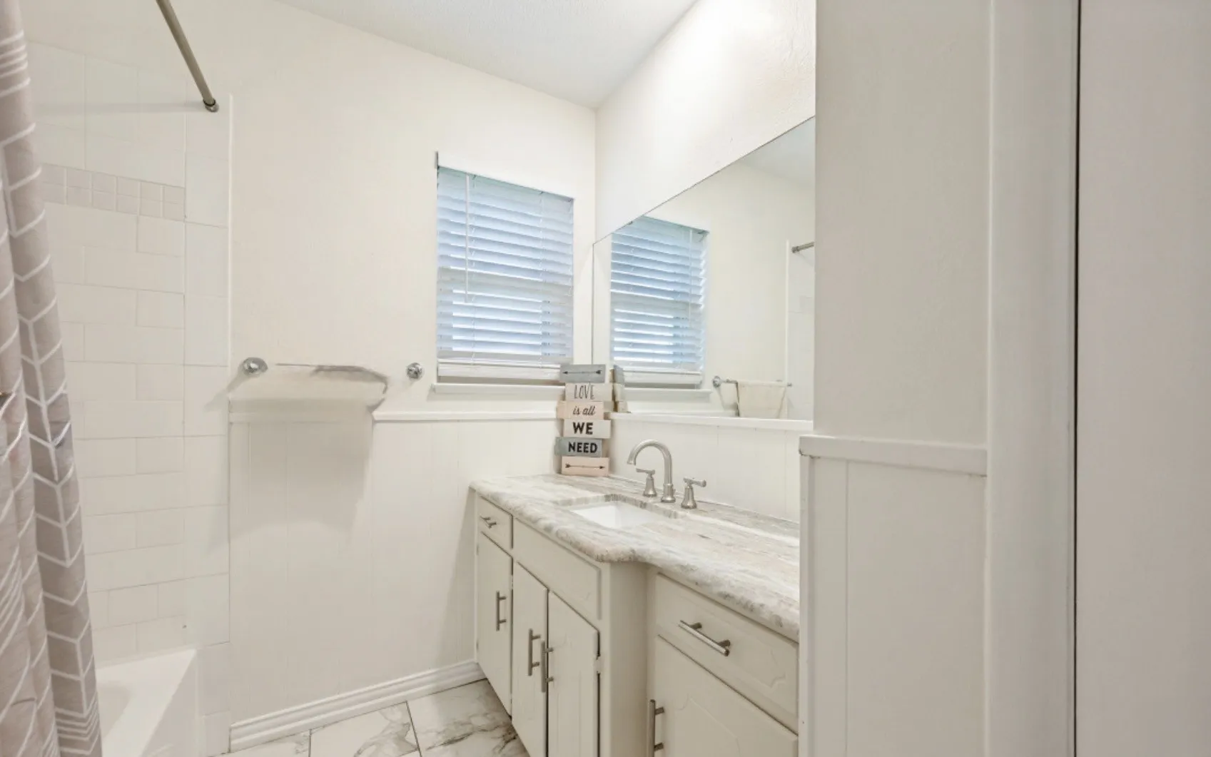 Bathroom vanity featuring a single sink, chrome faucet, and integrated countertop
