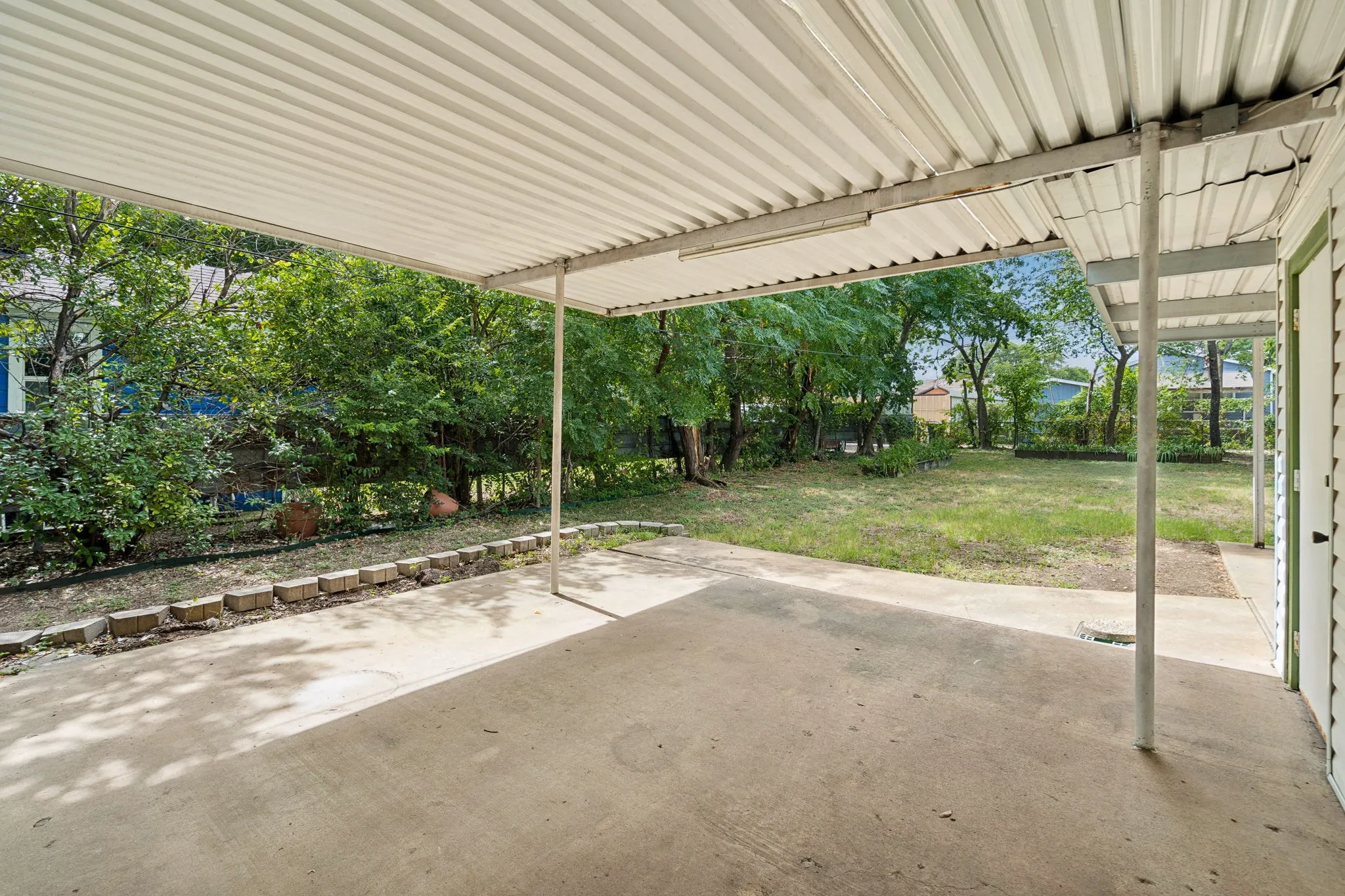 Covered concrete patio with a corrugated metal roof