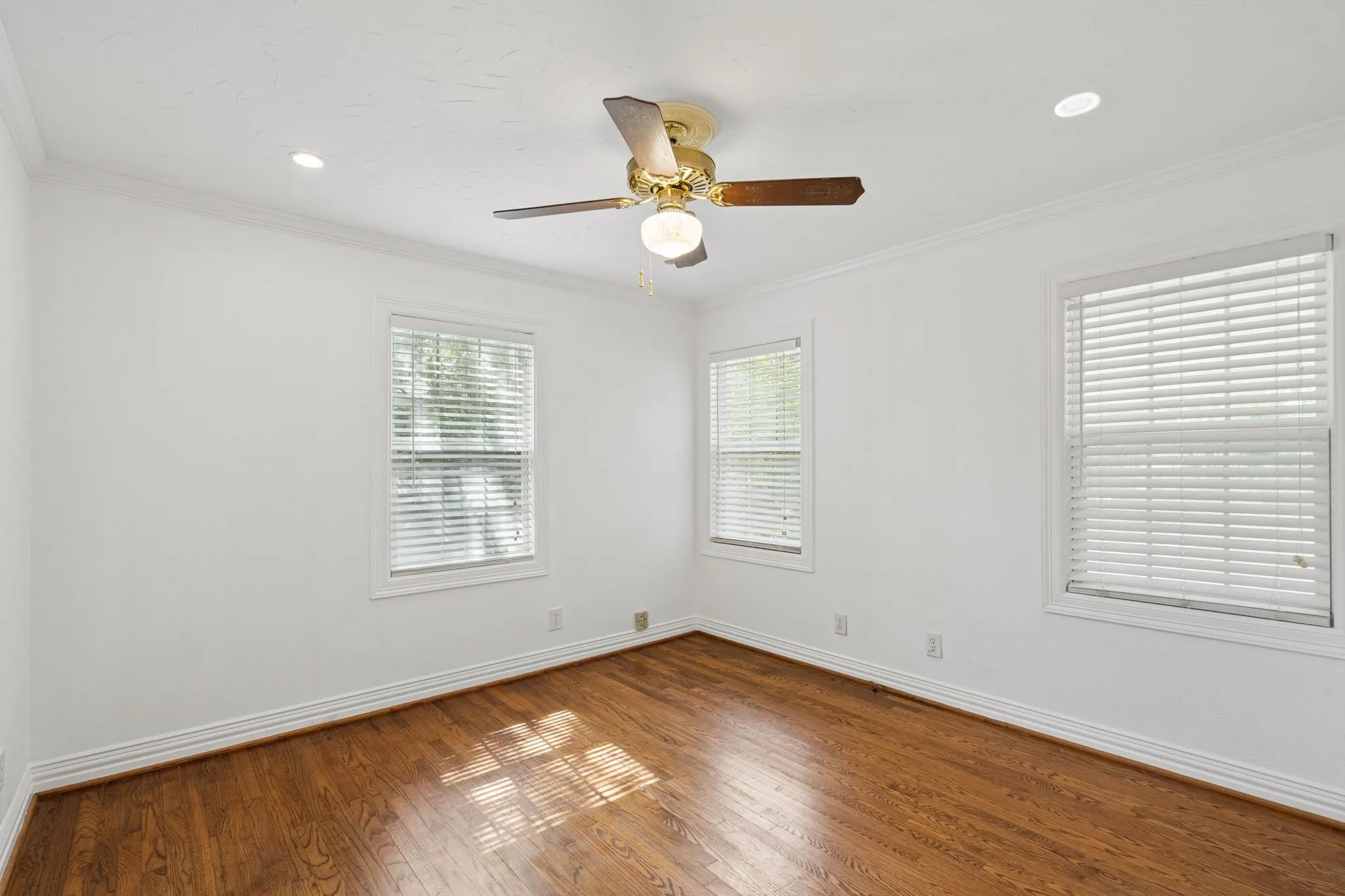 Bedroom featuring wood-finish flooring, white baseboards, and white walls