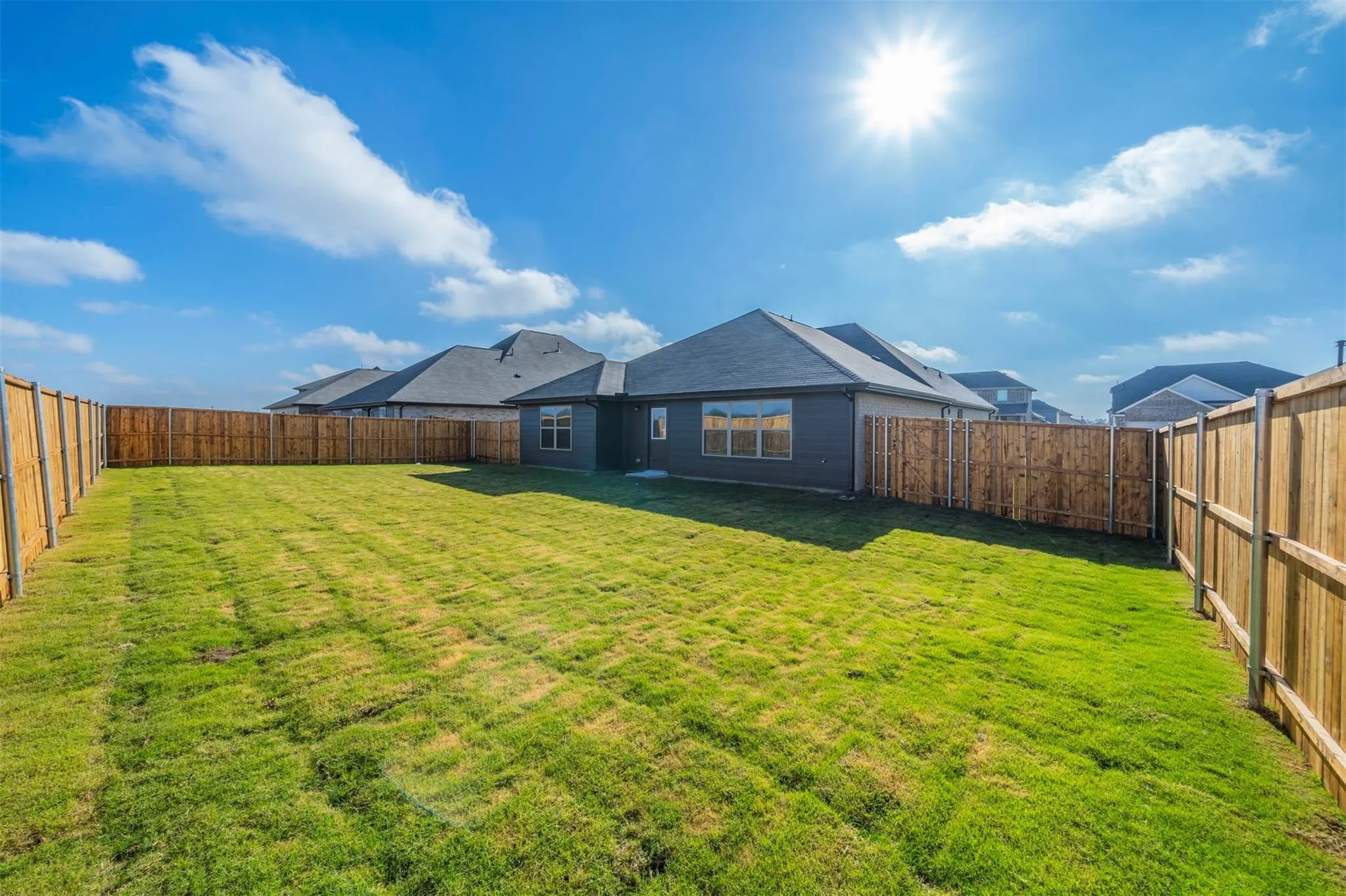 Expansive green lawn surrounded by a privacy fence